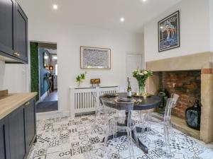 a kitchen with a table and chairs and a fireplace at Riverside Cottage in Belper