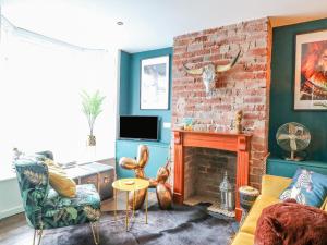 a living room with a couch and a fireplace at Riverside Cottage in Belper