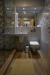 a bathroom with a sink and a toilet and a mirror at Hotel Tiara in Ploieşti