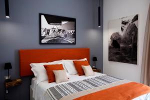 a bedroom with a bed with an orange headboard at Scugnizzo Apartment Luxury Home in Naples