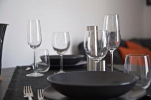 a table with wine glasses and a plate on it at Scugnizzo Apartment Luxury Home in Naples