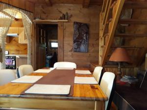 jadalnia z drewnianym stołem i białymi krzesłami w obiekcie Chata u Sylwii w Okunince