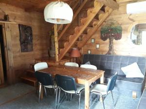 a dining room with a wooden table and chairs at Chata u Sylwii in Okuninka +15 photos