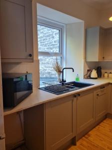 a kitchen with a sink and a window at Fisherman Cottage in Wick