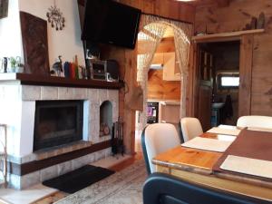 a living room with a fireplace and a table with chairs at Chata u Sylwii in Okuninka