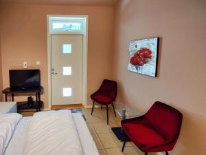 a bedroom with a bed and two chairs and a television at Kongsgata Apartments 