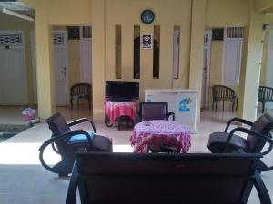 Cette chambre dispose d'une table, de chaises et d'une télévision. dans l'établissement Hotel Pekalongan Syariah Mitra RedDoorz, à Pekalongan