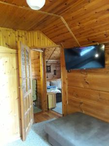 a room with a tv and a room with a bedroom at Chata u Sylwii in Okuninka