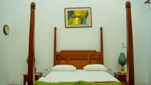 a bedroom with a large bed with a wooden frame at Flamingo Villa in Jaffna