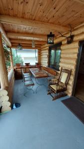 ein Raum mit Stühlen und einem Tisch in einer Blockhütte in der Unterkunft Cabana Raul in Gura Humorului