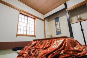 Łóżko lub łóżka w pokoju w obiekcie Komae House