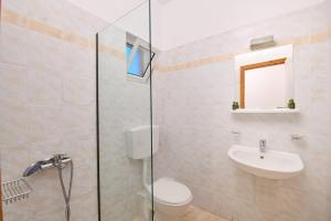 a bathroom with a shower and a toilet and a sink at En Armonia Hotel in Laganas