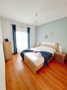 1 dormitorio con 1 cama grande y suelo de madera en Apartamento Vila Rosa - PRAIA DA ROCHA, en Portimão