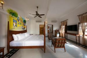 1 dormitorio con 1 cama y TV en Grand Hotel D'Europe, en Pondicherry