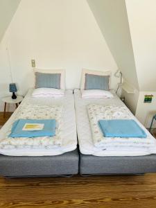 dos camas sentadas una al lado de la otra en una habitación en Færgestræde 45, en Marstal