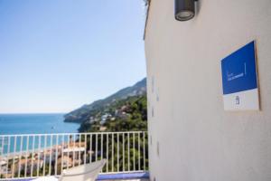 a sign on a building with a view of the ocean at Decori Suites Amalfi Coast in Vietri sul Mare