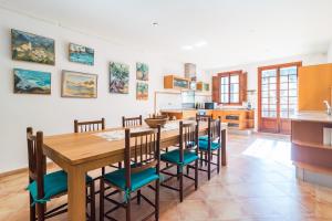 a kitchen and dining room with a wooden table and chairs at Coll den Pastor in Fornalutx