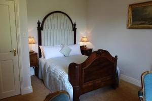 a bedroom with a large bed and two chairs at The East Wing in Glasbury