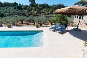 a pool with two chairs and an umbrella at Coll den Pastor in Fornalutx