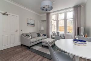 una sala de estar con una mesa y un sofá en 14 South Street, en St Andrews 15 fotos más
