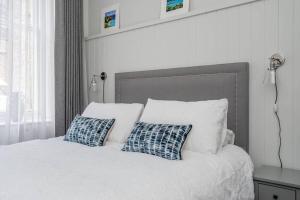 a white bed with two blue pillows on it at 14 South Street in St Andrews