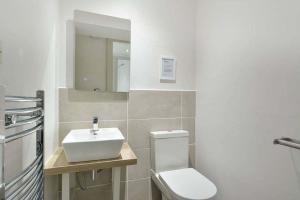 a bathroom with a white toilet and a sink at Kittocks Den in St Andrews