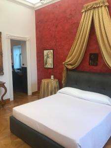 een slaapkamer met een wit bed en een rode muur bij Elegante appartamento nel centro di Roma in Rome