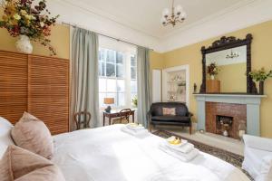 a bedroom with a white bed and a fireplace at Playfair Terrace in St Andrews