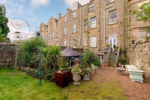 a garden in front of a large building with plants at Playfair Terrace in St Andrews