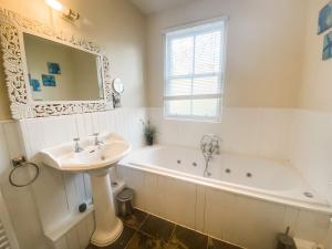 La salle de bains est pourvue d'un lavabo et d'une baignoire. dans l'établissement Sandmill, Murray Park, à St Andrews