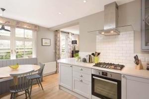 a kitchen with a table and a stove top oven at Steprock Cottage in St. Andrews