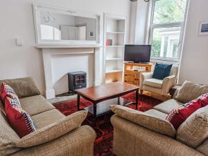 a living room with two couches and a table at Rosebank in St. Andrews