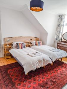 - 2 lits dans une chambre avec un tapis rouge dans l'établissement Rosebank, à St Andrews