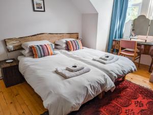 - une chambre avec un grand lit et des serviettes dans l'établissement Rosebank, à St Andrews