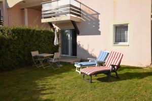 twee stoelen in het gras naast een huis bij Appartement 2 pièces RDC jardin dans résidence avec piscine in Arzon