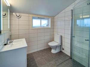 a bathroom with a toilet and a sink and a window at Kongsgata Apartments in Figgjo +73 photos