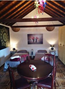 a dining room with a table and two beds at Suite Zen y Cueva Refugio in Tenteniguada