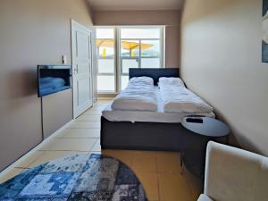 Habitación pequeña con 2 camas y ventana en Kongsgata Apartments 