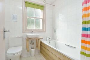a bathroom with a sink and a toilet and a tub at Kittocks Cottage in St. Andrews