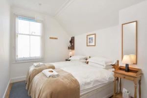 Heywood Cottage في سانت أندروز: غرفة نوم بيضاء مع سرير كبير عليه مناشف