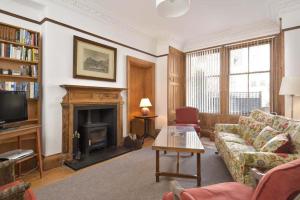 a living room with a couch and a fireplace at Heywood Cottage in St. Andrews