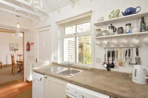 a white kitchen with a sink and a window at Heywood Cottage in St. Andrews