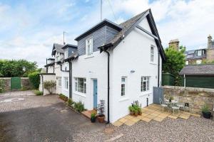 une maison blanche avec une allée devant dans l'établissement Willow Cottage, North Street, à St Andrews