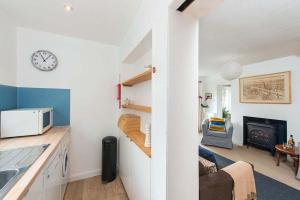 d'une cuisine et d'un salon avec une horloge murale. dans l'établissement Willow Cottage, North Street, à St Andrews