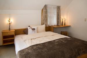 a bedroom with a large bed and a window at Bödele Alpenhotel in Schwarzenberg im Bregenzerwald