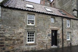 an old stone building with windows and a roof at The Wee House in St. Andrews