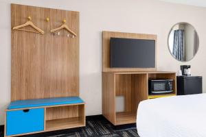 a hotel room with a bed and a tv at Days Inn by Wyndham Paris in Paris