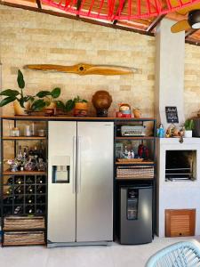 uma cozinha com um frigorífico de aço inoxidável num quarto em Cobertura Duplex com piscina e Suítes Barão Vermelho em Morro de São Paulo