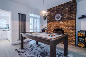 a room with a pool table and a brick fireplace at Faulkner House in Chester