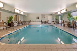 a pool in a hotel room with chairs and tables at Best Western Hilliard Inn & Suites in Hilliard